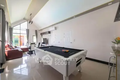 Spacious living room with pool table and modern decor, perfect for entertainment and relaxation.