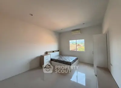 Spacious bedroom with natural light and modern furnishings, perfect for comfort and relaxation.