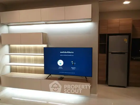 Modern living room with sleek TV setup and stylish kitchen appliances