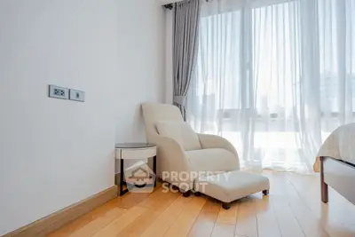 Bright and cozy bedroom corner with modern armchair and natural light