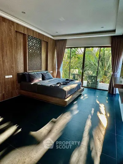 Luxurious bedroom with modern design and large windows overlooking lush greenery.