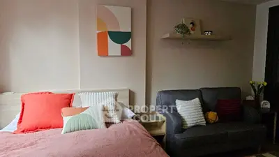 Cozy bedroom with modern decor and comfortable seating area.