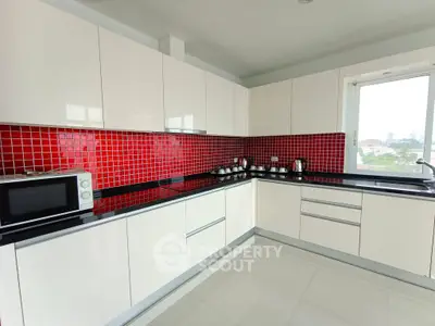 Modern kitchen with sleek white cabinets and vibrant red backsplash