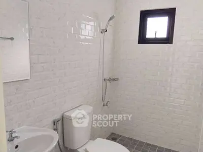 Modern bathroom with white brick tiles and compact fixtures