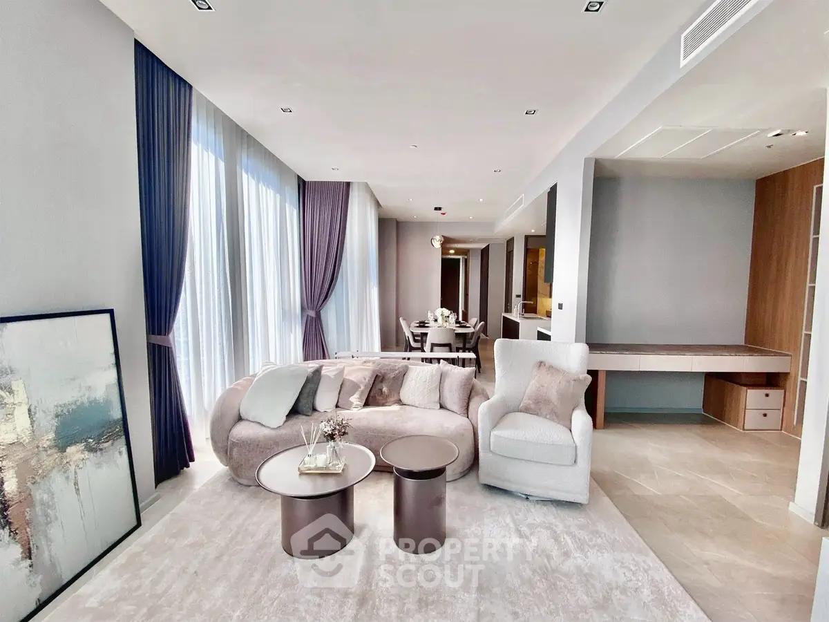Luxurious modern living room with elegant furniture and floor-to-ceiling windows in a high-end apartment.