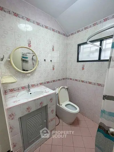 Charming bathroom with vintage floral tiles and modern fixtures, perfect for a cozy home ambiance.