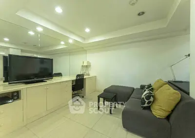 Modern living room with sleek furniture and large TV, perfect for relaxation and entertainment.