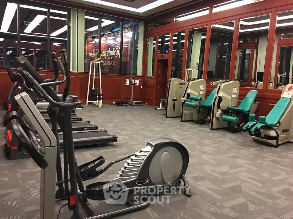Spacious gym with modern fitness equipment in upscale residential building.