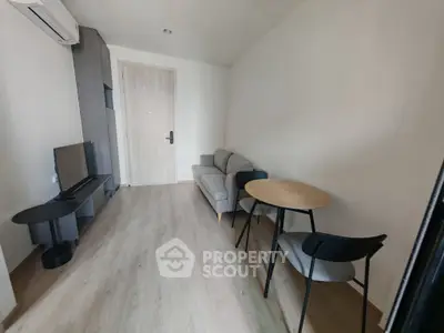 Modern minimalist living room with sleek furniture and wooden flooring, perfect for cozy urban living.