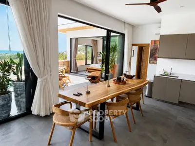 Stunning open-plan kitchen and dining area with ocean view and modern decor.