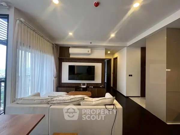 Modern living room with sleek design and large windows offering natural light.