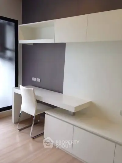 Modern study room with sleek white furniture and built-in storage