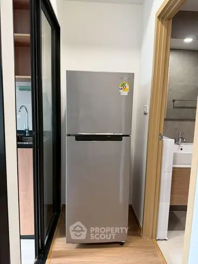 Modern apartment with sleek stainless steel fridge near kitchen and bathroom