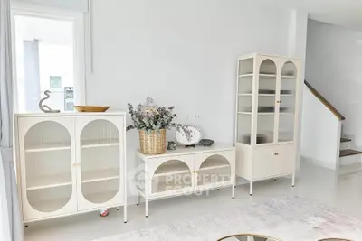 Stylish modern living room with elegant white cabinets and decorative accents.