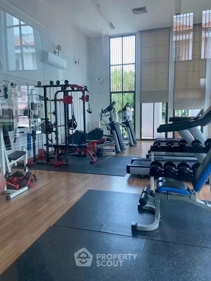 Modern gym with state-of-the-art equipment and large windows for natural light.