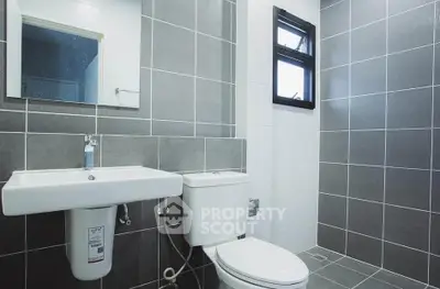 Modern bathroom with sleek gray tiles and contemporary fixtures.