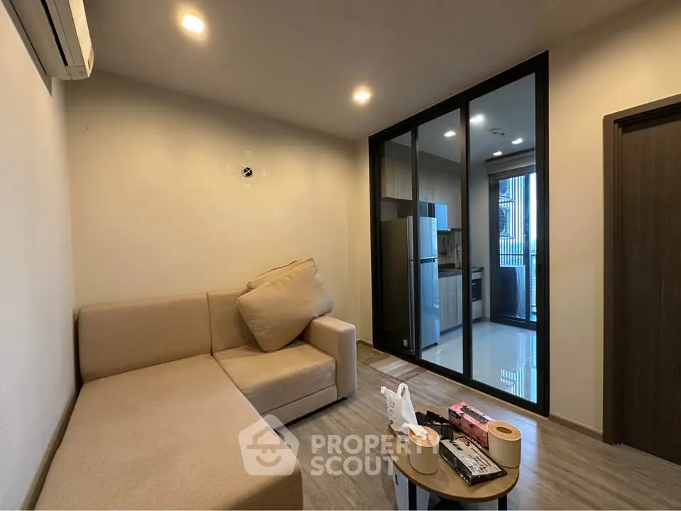 Modern living room with cozy sofa and open kitchen layout in stylish apartment.