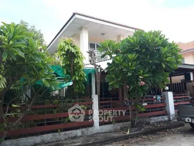 Charming two-story house with lush garden and spacious front yard in a serene neighborhood.