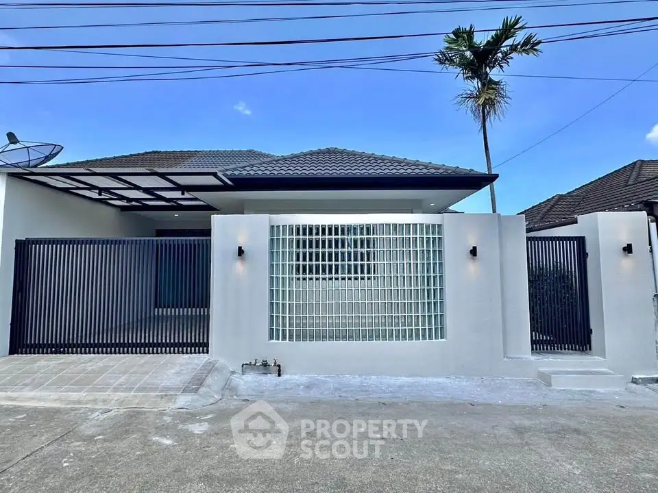 Modern single-story house with sleek fence and glass block wall, perfect for contemporary living.