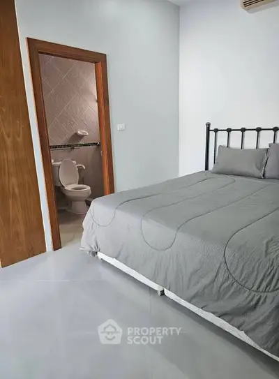 Cozy bedroom with ensuite bathroom, featuring modern decor and neutral tones for a relaxing atmosphere.