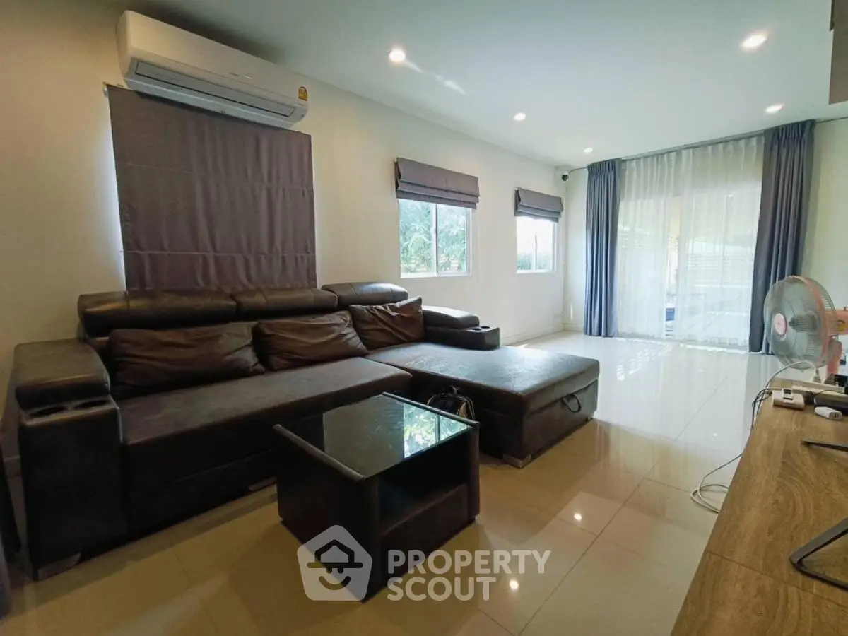 Spacious modern living room with leather sofa and large windows