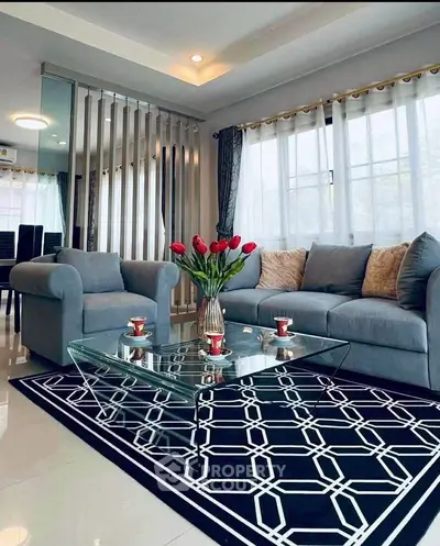 Stylish living room with modern decor, glass coffee table, and cozy seating in a bright, airy space.