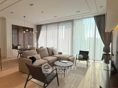 Luxurious modern living room with floor-to-ceiling windows and elegant furnishings.