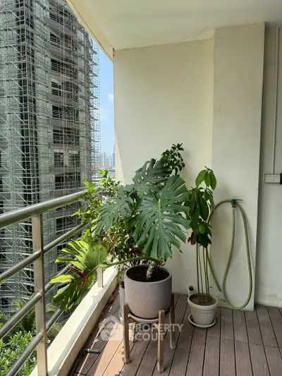 Spacious balcony with lush potted plants and city view, perfect for relaxation and enjoying the outdoors.