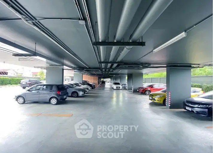 Spacious underground parking area with multiple cars and ample lighting.