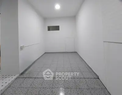 Spacious white interior room with tiled floor, ideal for storage or utility use.