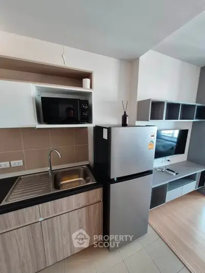 Modern kitchen with sleek appliances and stylish cabinetry in a contemporary apartment.