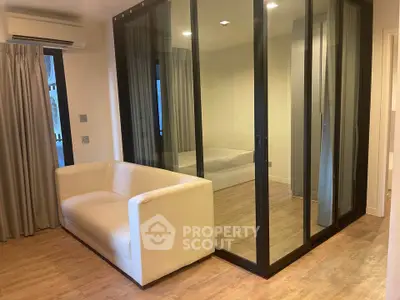 Modern apartment with glass-walled bedroom and cozy living area