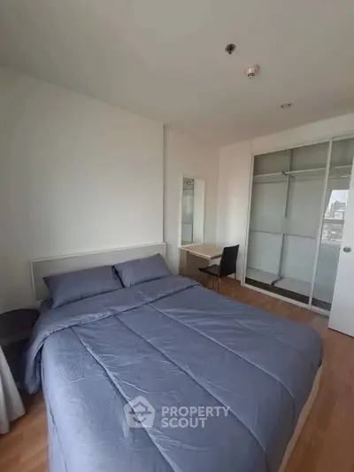 Spacious bedroom with modern furnishings and ample natural light in a stylish apartment.