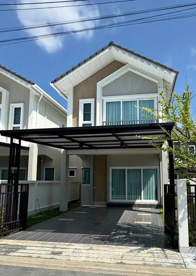 Modern two-story house with carport and large windows in a suburban neighborhood.