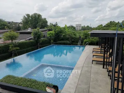 Luxurious outdoor pool area with lush greenery and modern lounge chairs