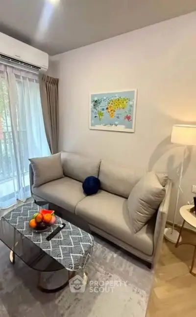 Chic living room with cozy sofa, stylish decor, and natural light from large window.