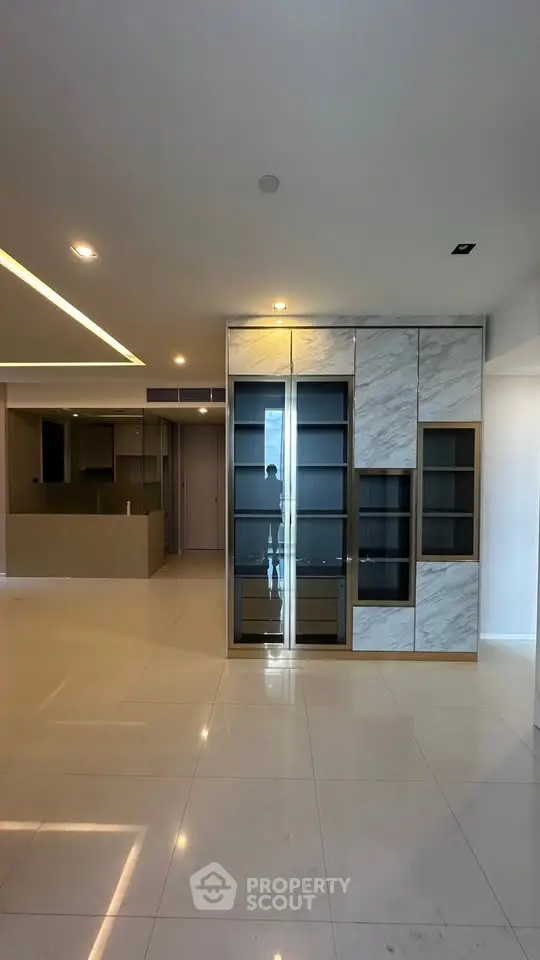 Spacious modern living room with elegant built-in storage and open kitchen layout.