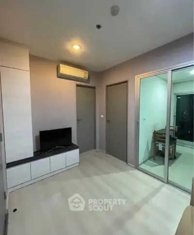 Modern living room with air conditioning and sliding glass doors in a cozy apartment.