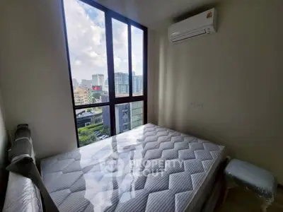 Modern bedroom with large window offering city view and air conditioning