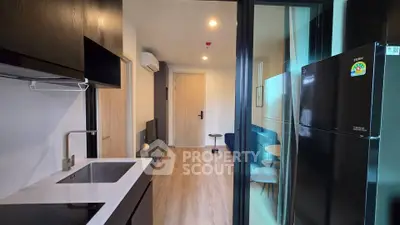 Modern apartment interior with sleek kitchen and cozy living area, featuring stylish decor and efficient layout.