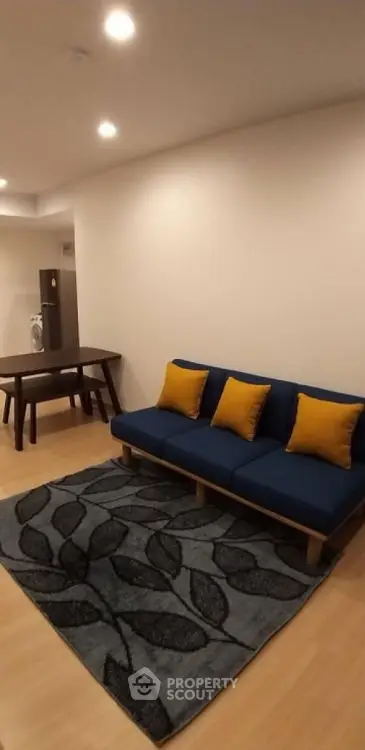 Modern living room with stylish blue sofa and decorative rug