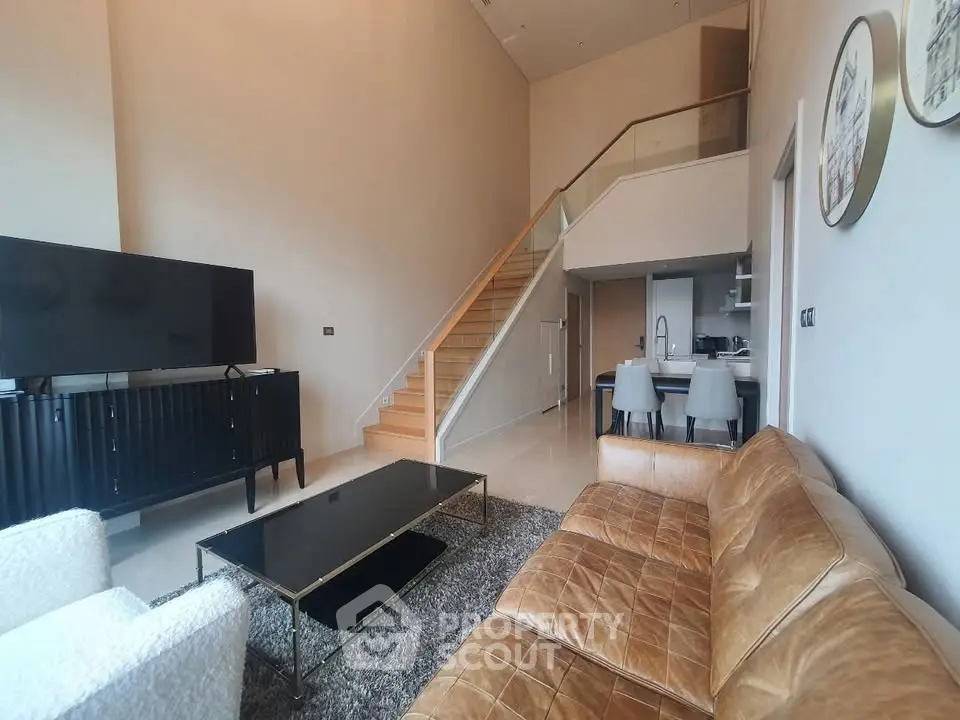 Modern living room with stylish furniture and open staircase in a luxury apartment