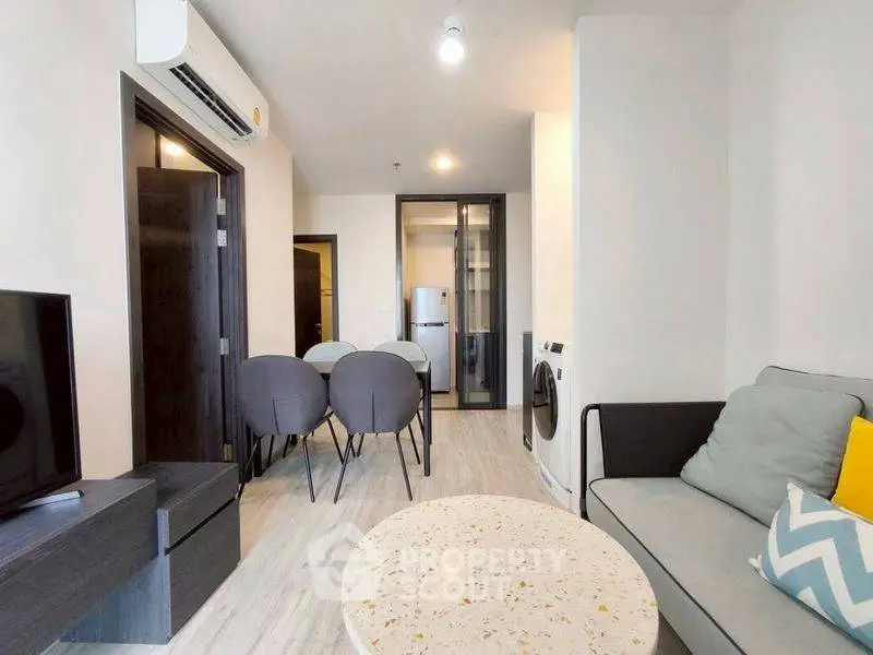 Modern living room with open layout, featuring stylish furniture and appliances.