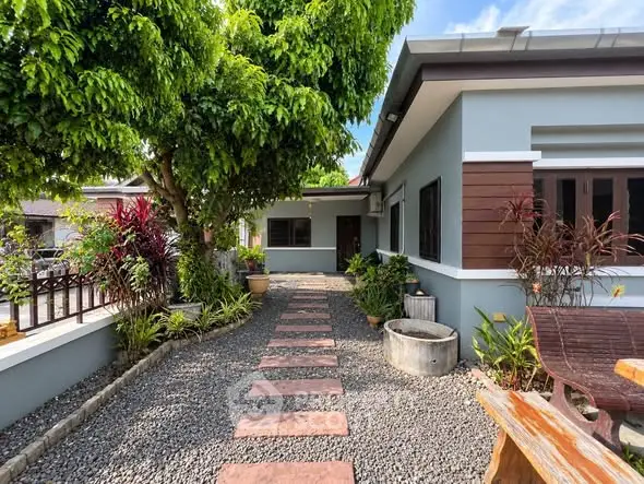 Charming single-story home with lush garden and inviting pathway, perfect for serene living.
