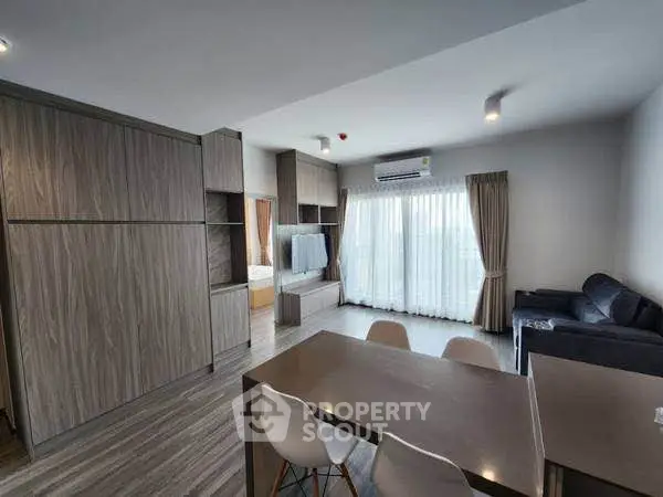 Modern open-plan living room with dining area and large windows