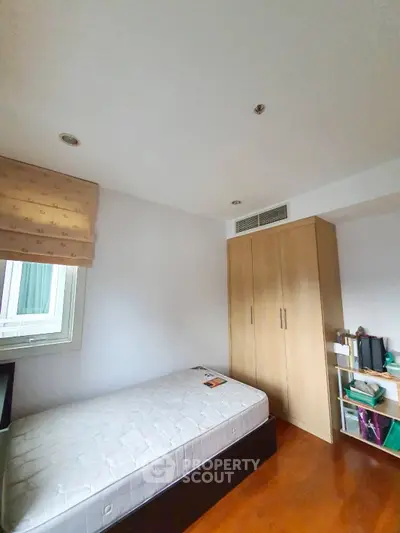 Cozy bedroom with single bed and built-in wardrobe, perfect for minimalist living.