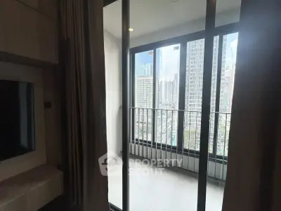 Modern apartment with balcony offering stunning city views through floor-to-ceiling windows.