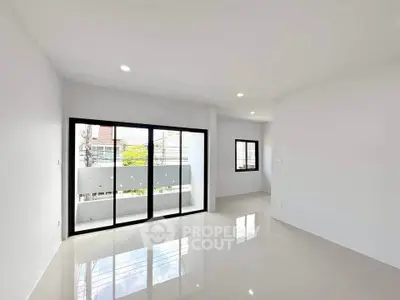 Spacious modern living room with large windows and glossy tiled floors