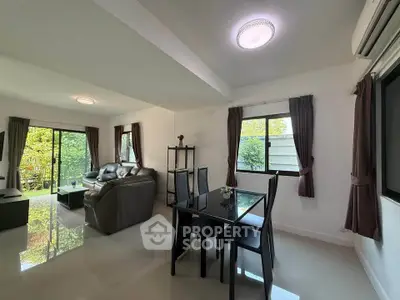 Spacious living room with modern furniture and large windows overlooking greenery.