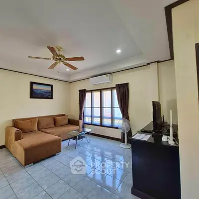 Spacious living room with cozy sofa and modern ceiling fan